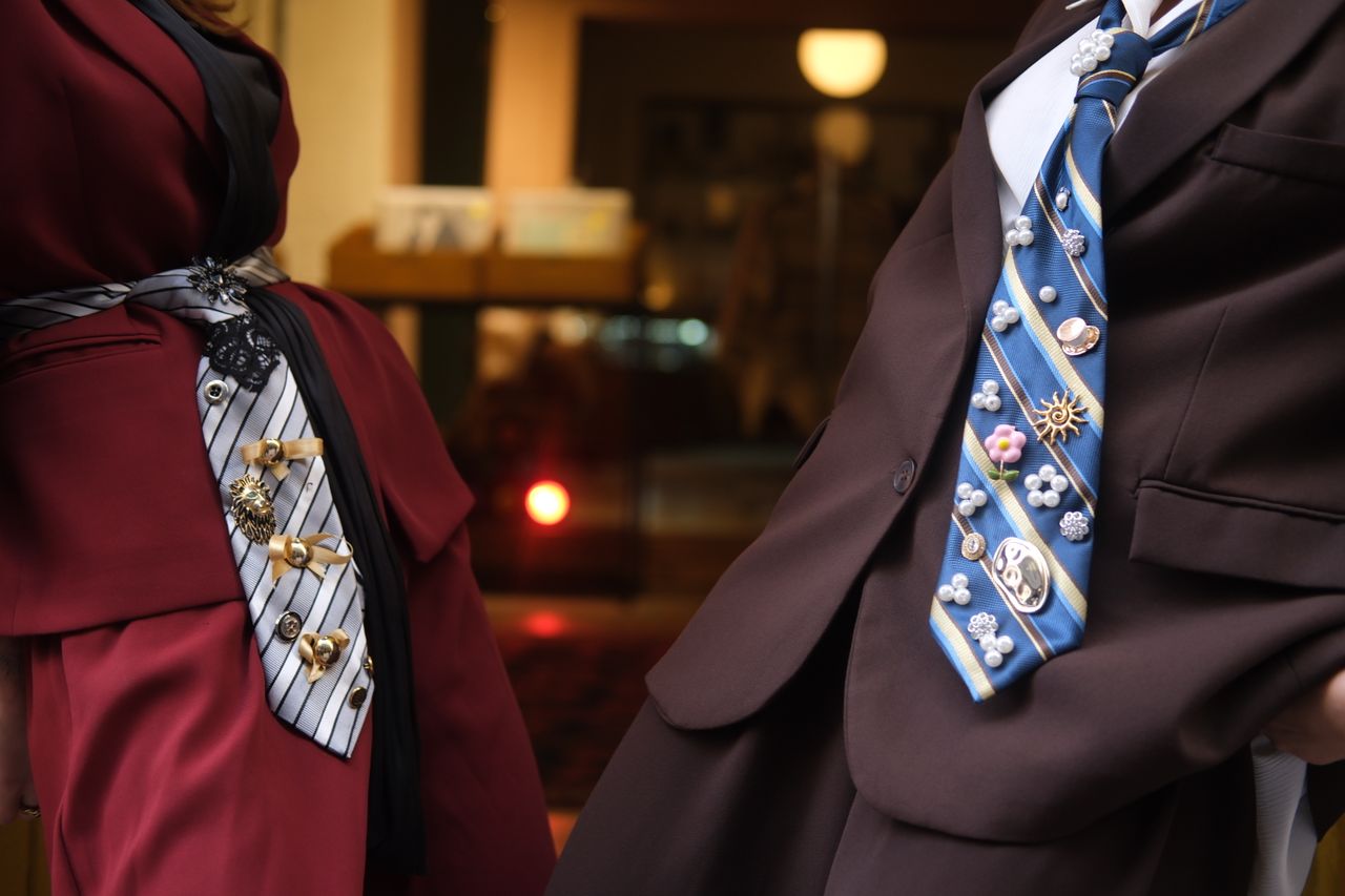 about-img-01 Close-up of two stylishly adorned ties with unique pins, showcasing modern fashion in suits.